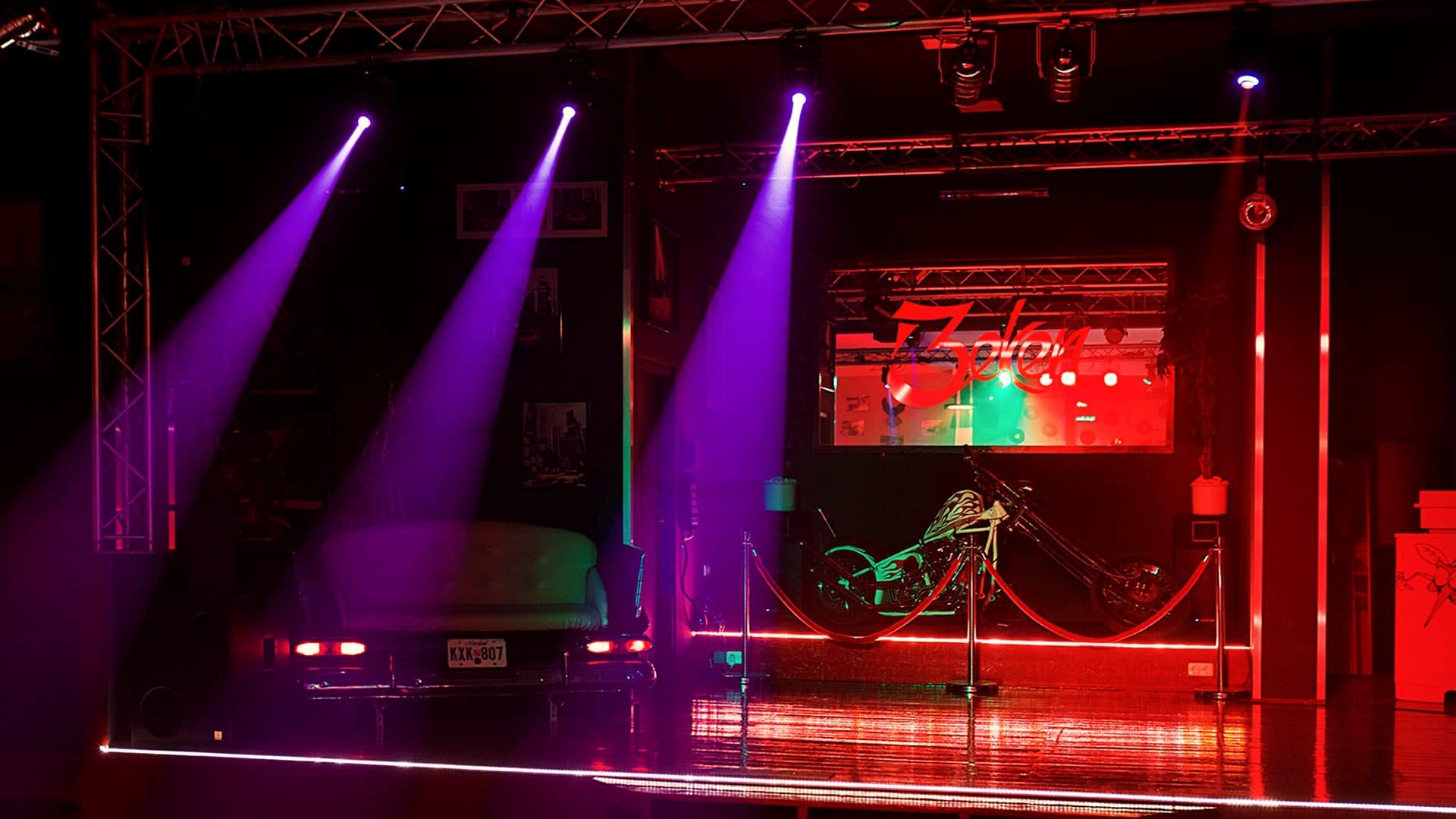 Bühne mit violetten Lichtstrahlen und rot leuchtender Bühnenkante