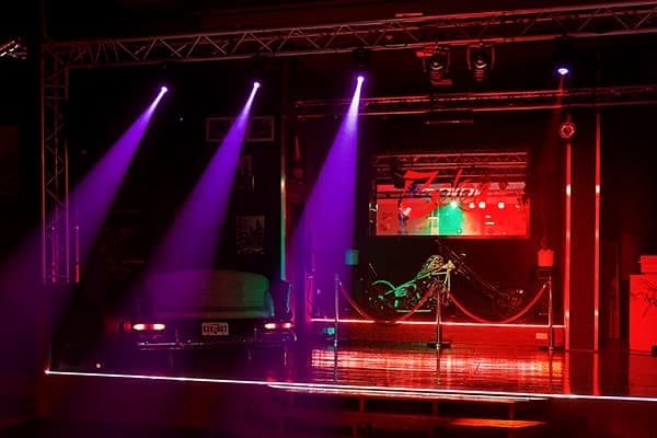Bühne im Dreibeken mit violetten Lichtkegeln, Lichttraverse und rot leuchtender Bühnenkante