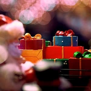 Weihnachtsmann-Figur neben bunt verpackten Geschenken